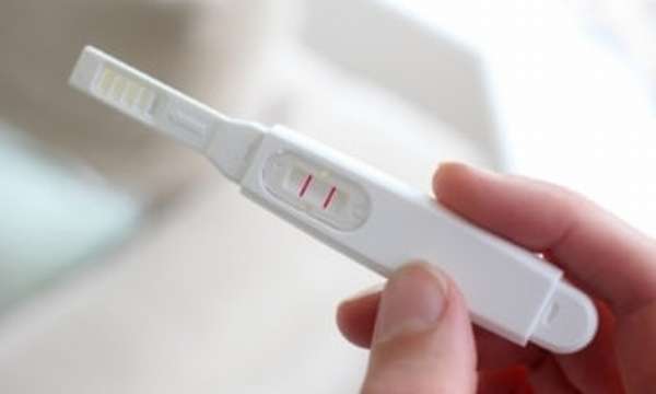 Тест на беременность у девушки в руках