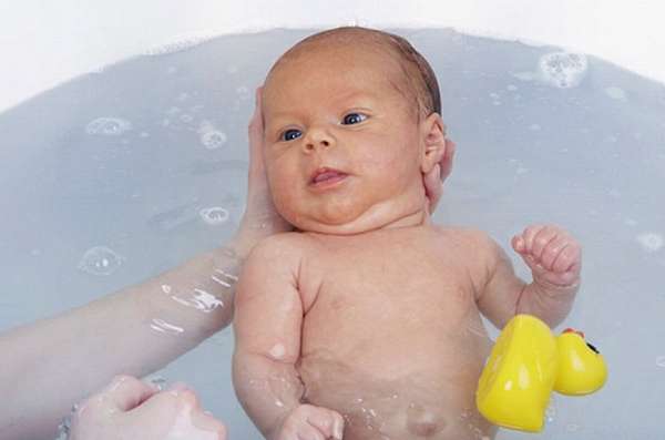 Узнайте, как держать новорожденного при купании.