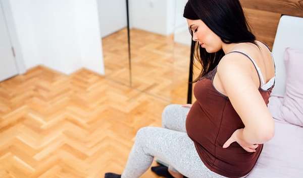 На 27 акушерской неделе беременности у многих женщин начинает болезненно ощущаться крестец из-за нарастающей нагрузки на позвоночник.