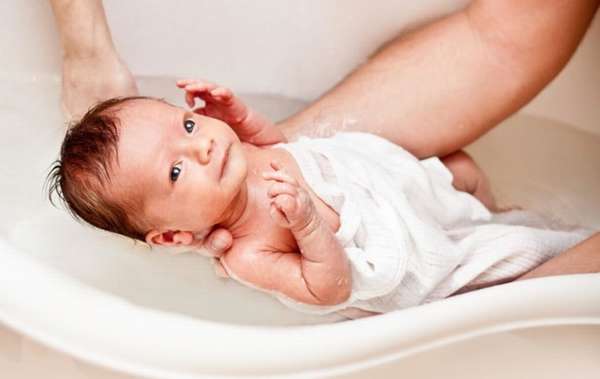 Узнайте, как купать новорожденного ребенка в ванночке.